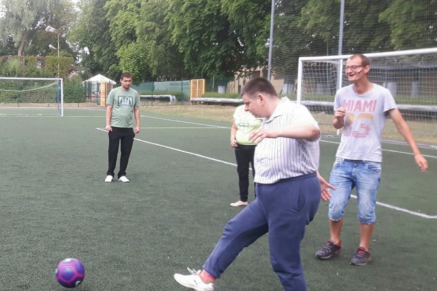 Uczestniczka kopiąca piłkę na tle uczestników