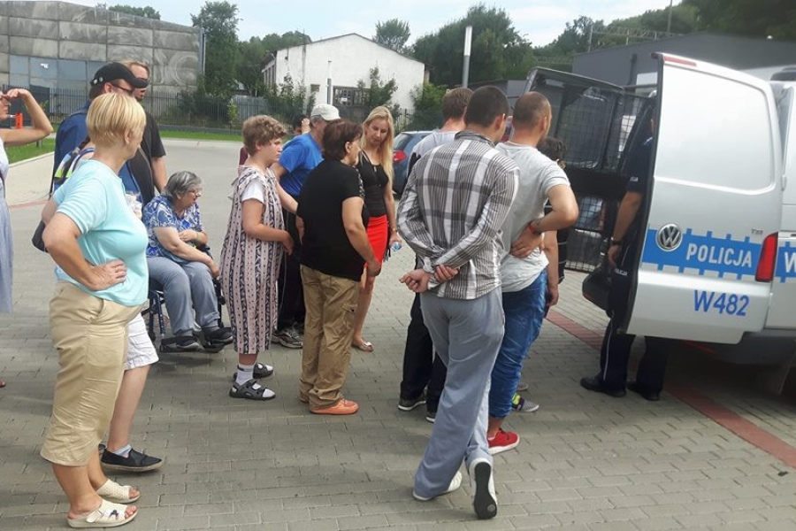 Policjant przedstawiający uczestnikom wnętrze radiowozu 