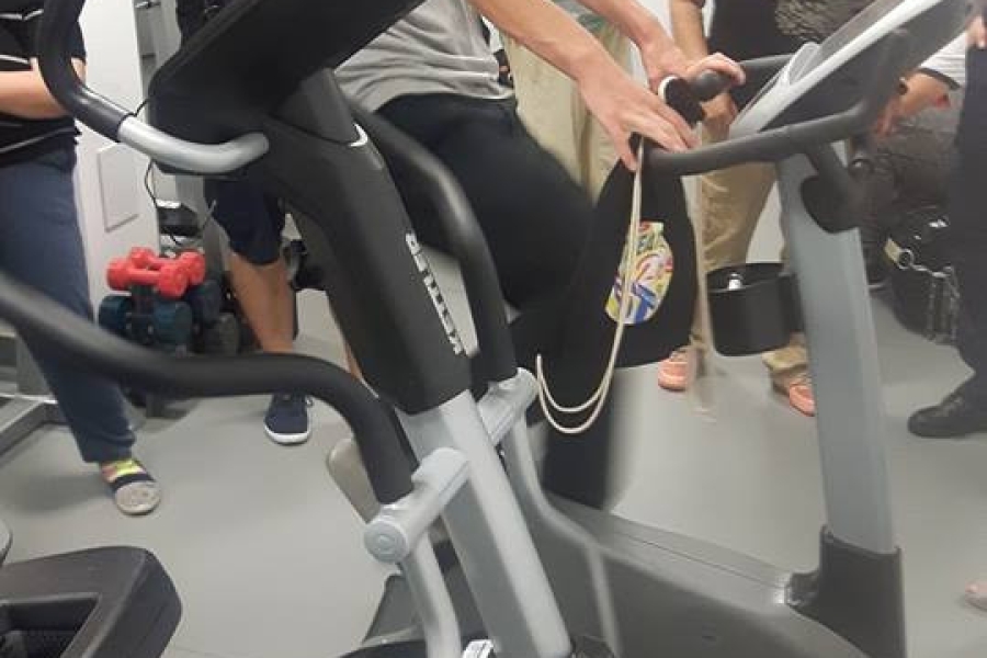 Uczestnik ćwiczący na rowerku stacjonarnym na policyjnej siłowni