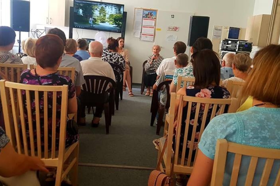 Uczestnicy siedzący na krzesłach, słuchający przemówienia