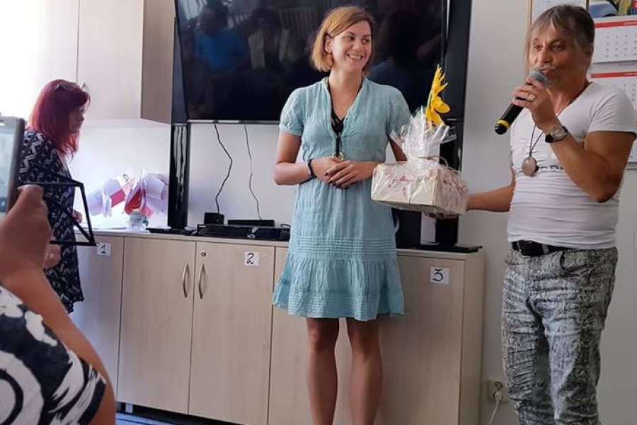 Przemawiający gość trzymający w ręku upominek