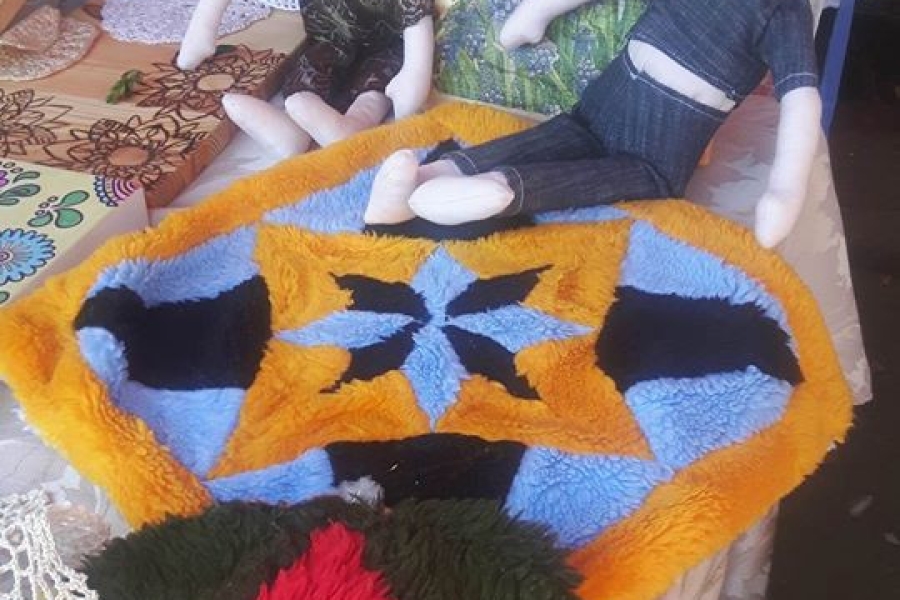 Materiałowe lalki siedzące na kolorowych serwetkach