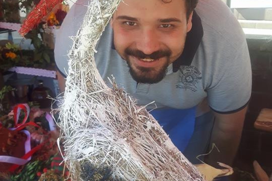 Uczestnik skrywający się za słomianym bocianem