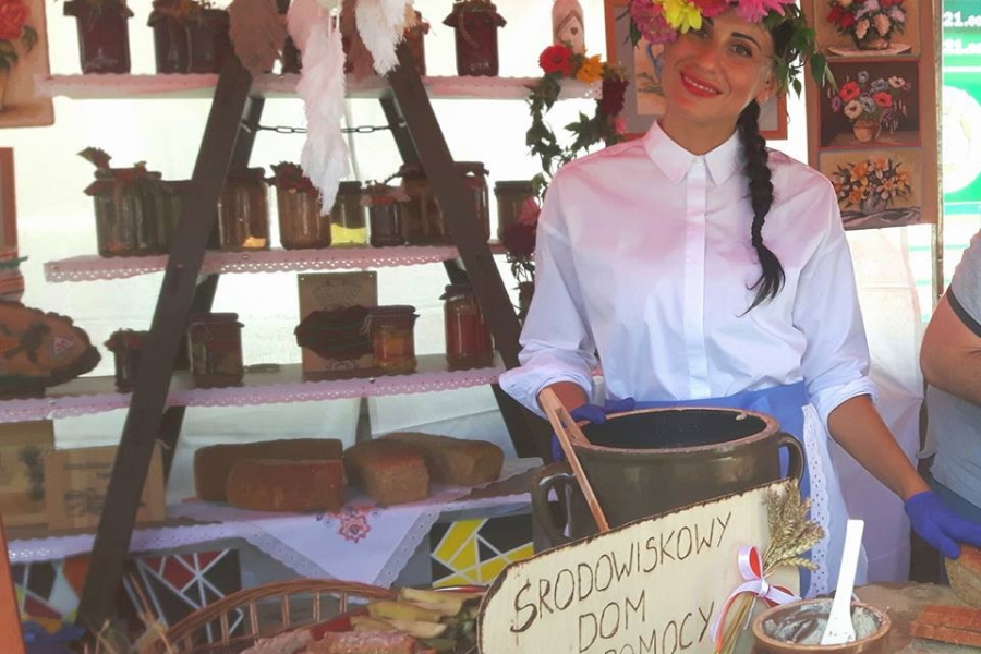 Terapeutka z wiankiem na głowie trzymająca garnek z kiszonymi ogórkami