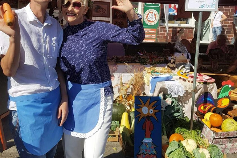 Uśmiechnięta Pani Kierownik ŚDS wraz z uczestnikiem trzymającym marchew