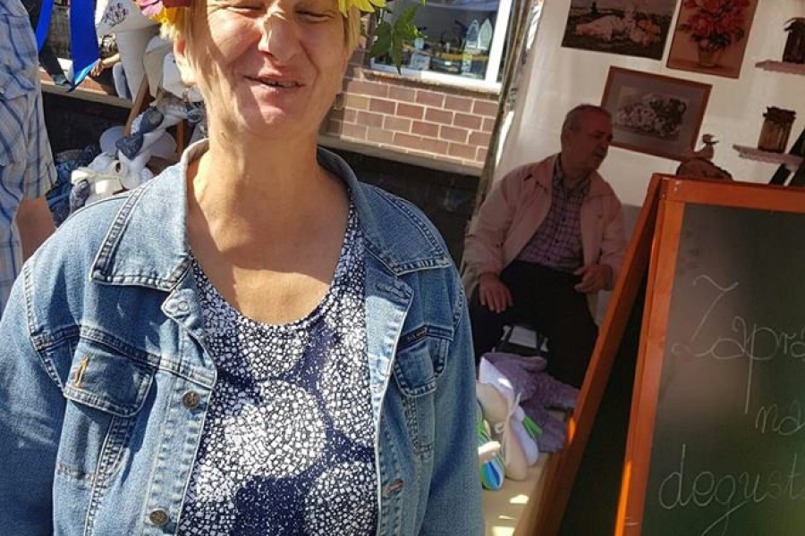 Uczestniczka z wiankiem na głowie, uśmiechająca się do zdjęcia