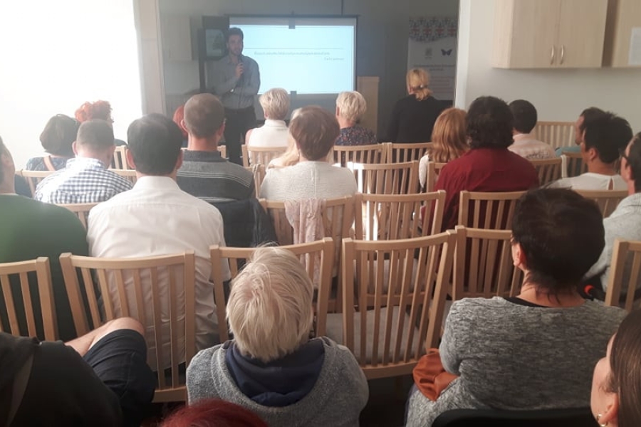 Uczestnicy oraz gości siedzący na krzesłach podczas wykładu