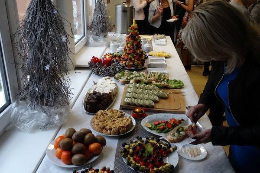 Uczestnicy przy stole z poczęstunkiem