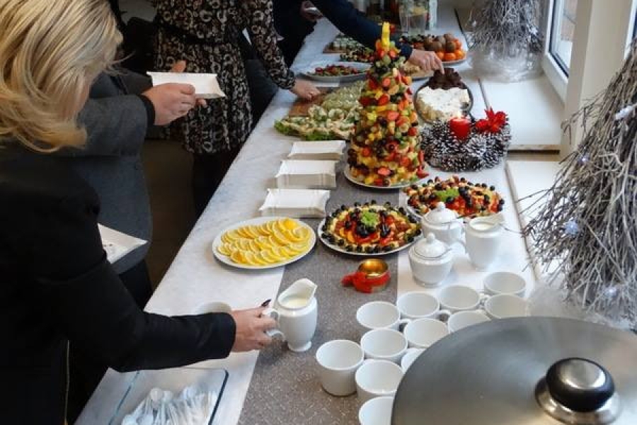 Uczestnicy przy stole z poczęstunkiem