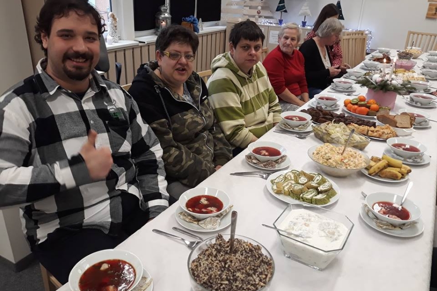 Uczestnicy pozujący do zdjęcia przy stole wigilijnym