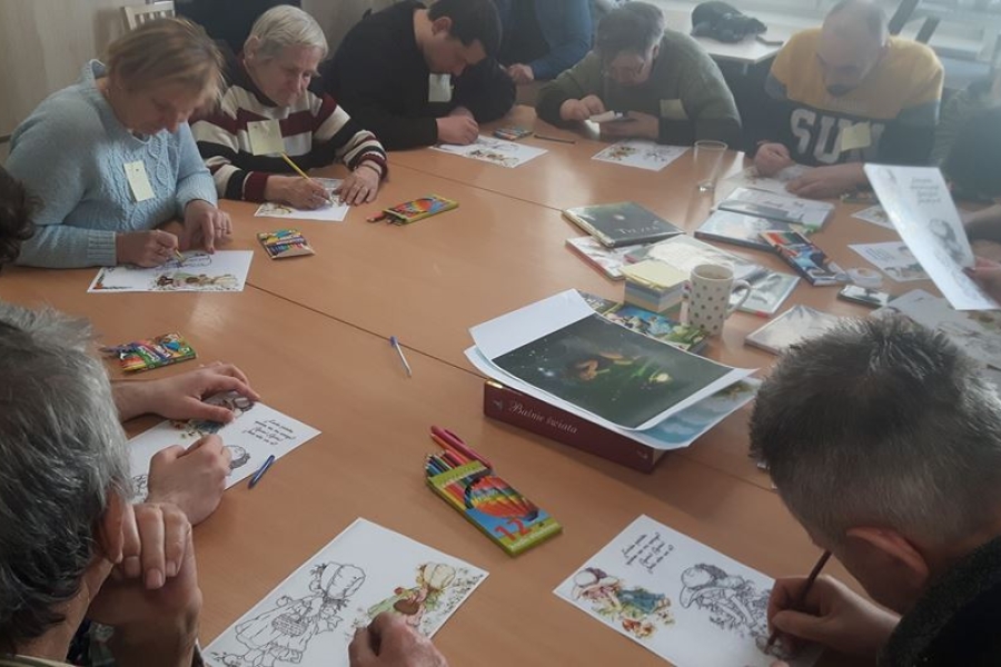 Grupa uczestników wykonujących prace artystyczną.