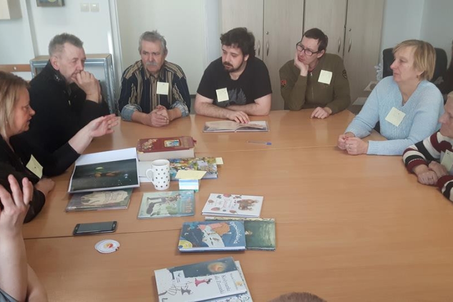 Grupa uczestników podczas słuchania opowiadania.