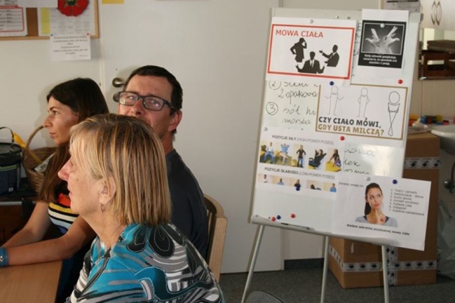 Uczestnicy na tle tablicy z plakatami.