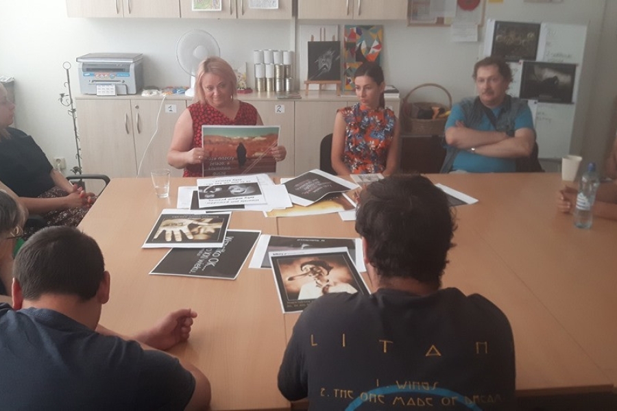 Terapeutka przedstawiająca plakaty uczestnikom.