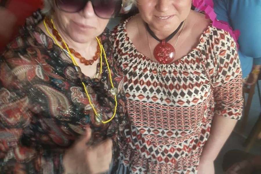 Dwoje uczestników pozuje do zdjęcia w kolorowych strojach.