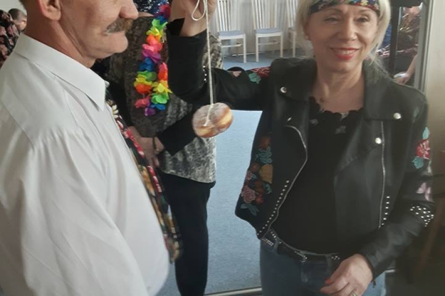 Kobieta trzymająca pączka na sznurku w ramach zabawy.