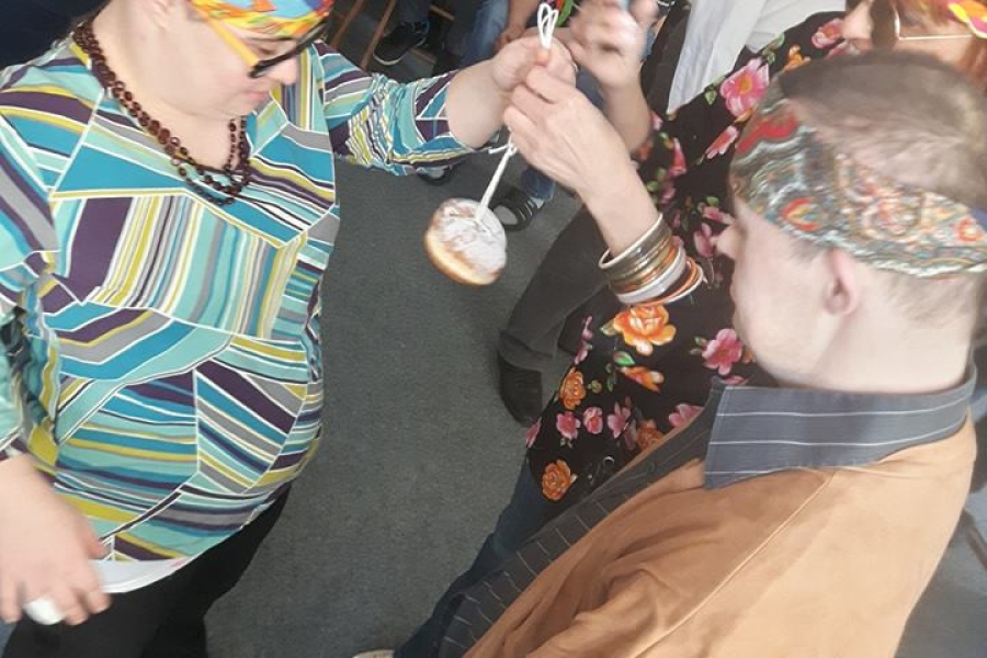 Dwoje uczestników przystępuje do zabawy z pączkiem.