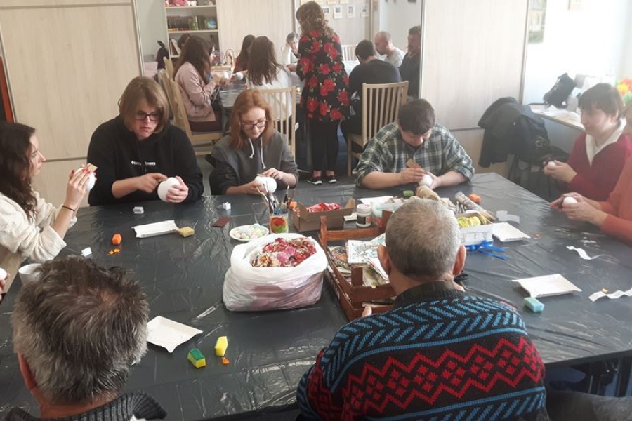 Uczestnicy wraz z terapeutą wykonującym pracę metodą decoupage.