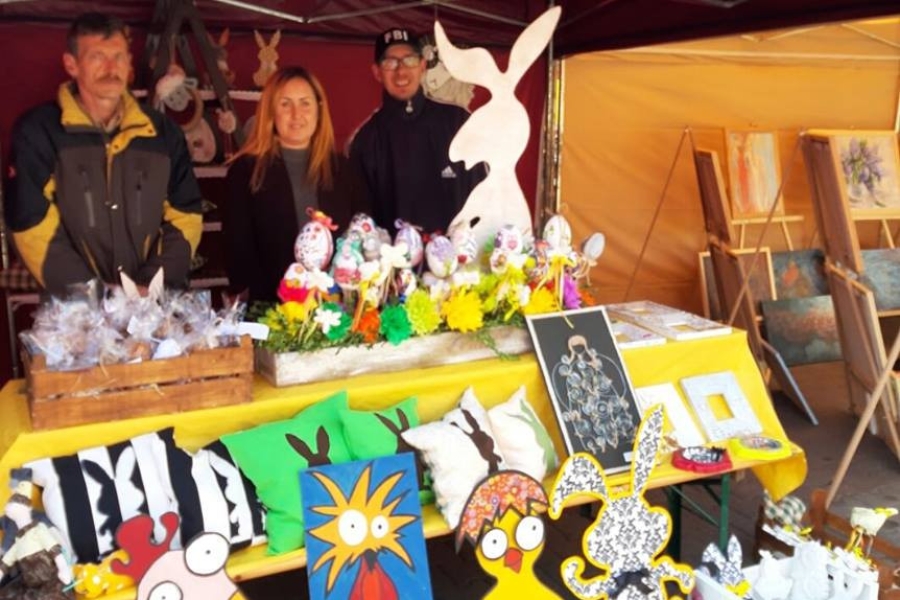 Uczestnicy wraz z terapeutką na straganie z pracami wielkanocnymi.