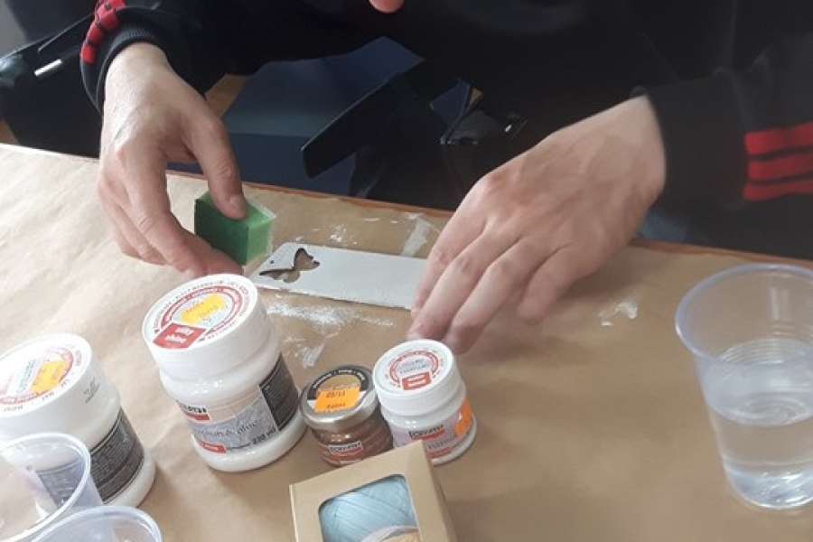 Uczestnik wykonujący pracę metodą decoupage.