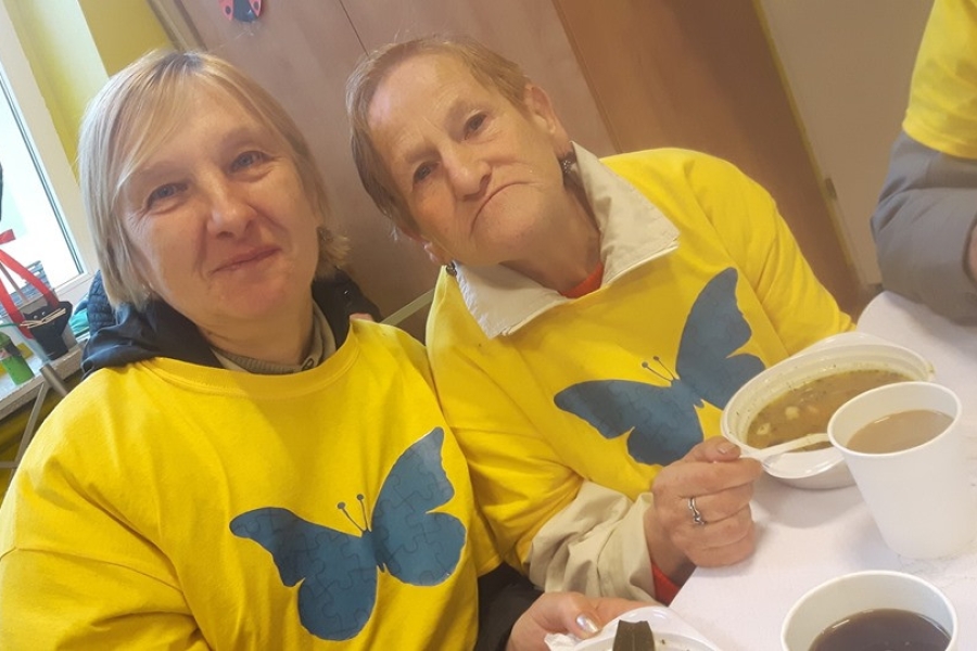 Dwoje uczestniczek jedzących ciepły posiłek.