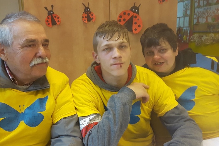 Trójka uczestników pozujących do zdjęcia w pomieszczeniu.
