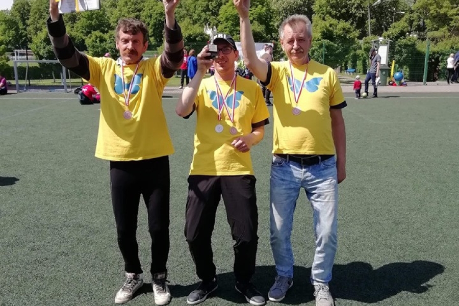 Trójka triumfujących uczestników trzymających nagrody