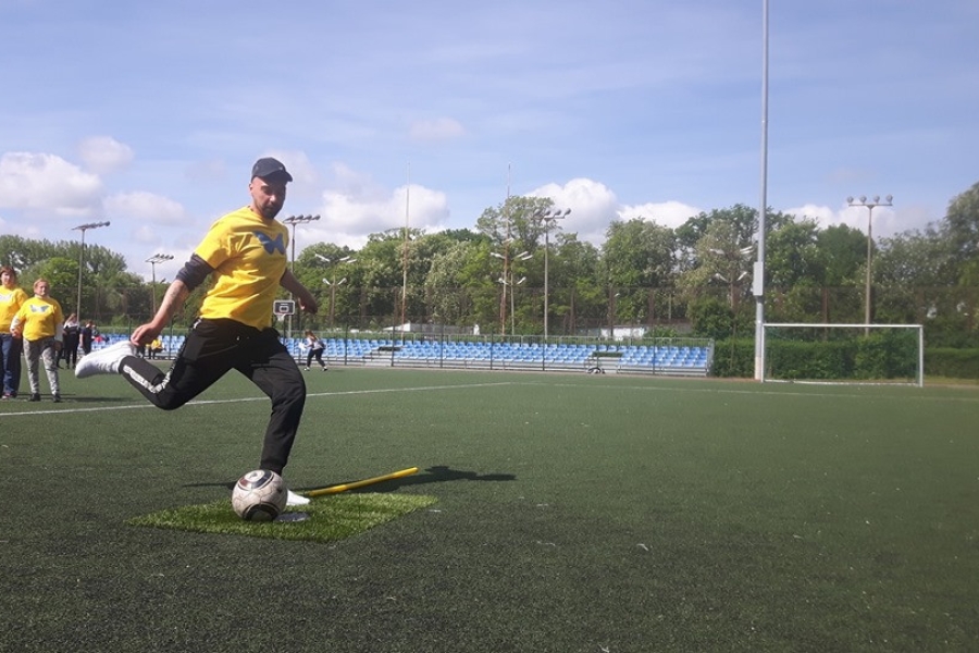 Uczestnik wykopujący piłkę na stadionie