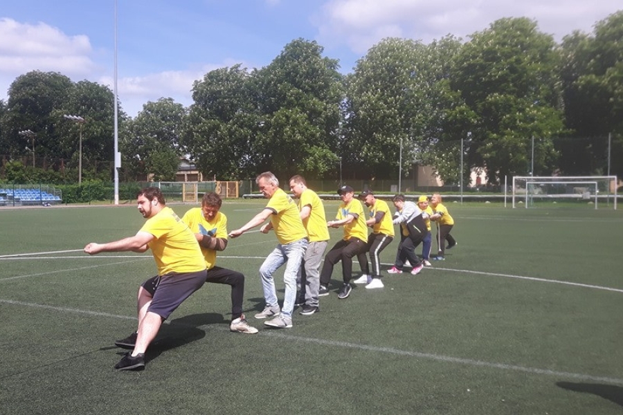 Uczestnicy ŚDS przeciągający linę na boisku