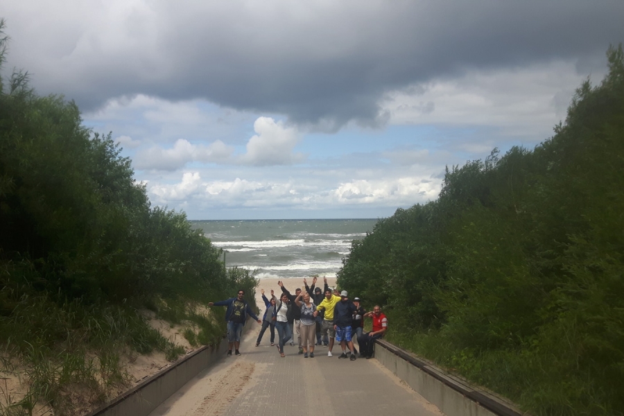 Grupa uczestników na tle zejścia na plaże.