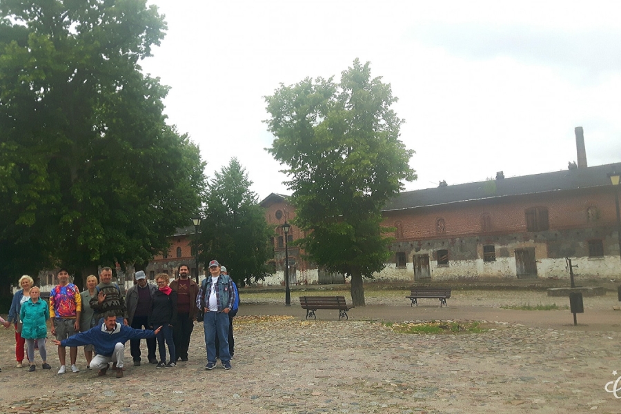 Uczestnik odpoczywa na ławce na tle ceglanego budynku.