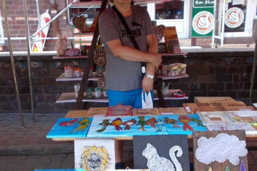 Uczestnik prezentujący rękodzieła wykonane przez uczestników ŚDS