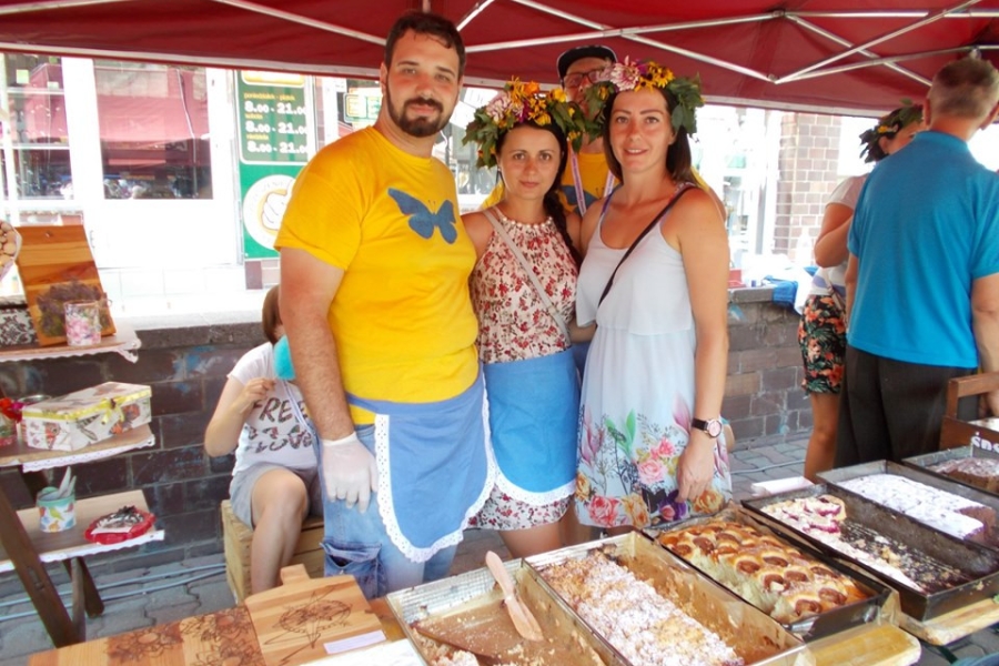 Kadra ŚDS z uczestnikiem pozująca do zdjęcia przy stole z poczęstunkiem