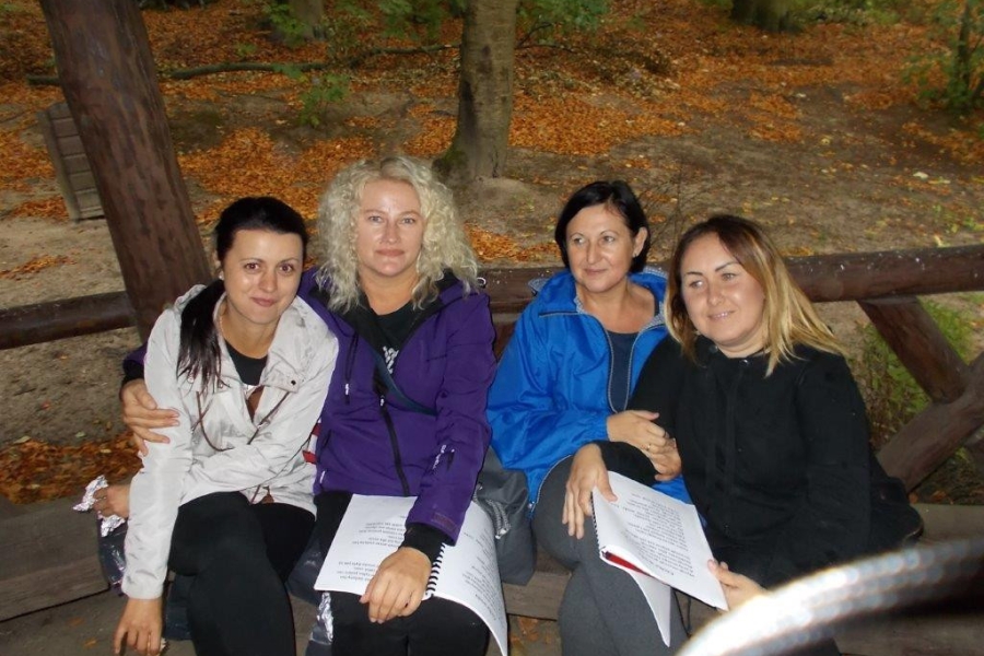 Kadra pracownicza ŚDS siedząca na ławce pod altaną