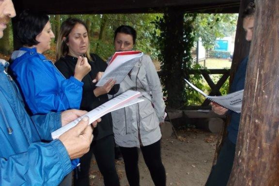 Uczestniczy wraz z terapeutami śpiewają piosenki pod altaną