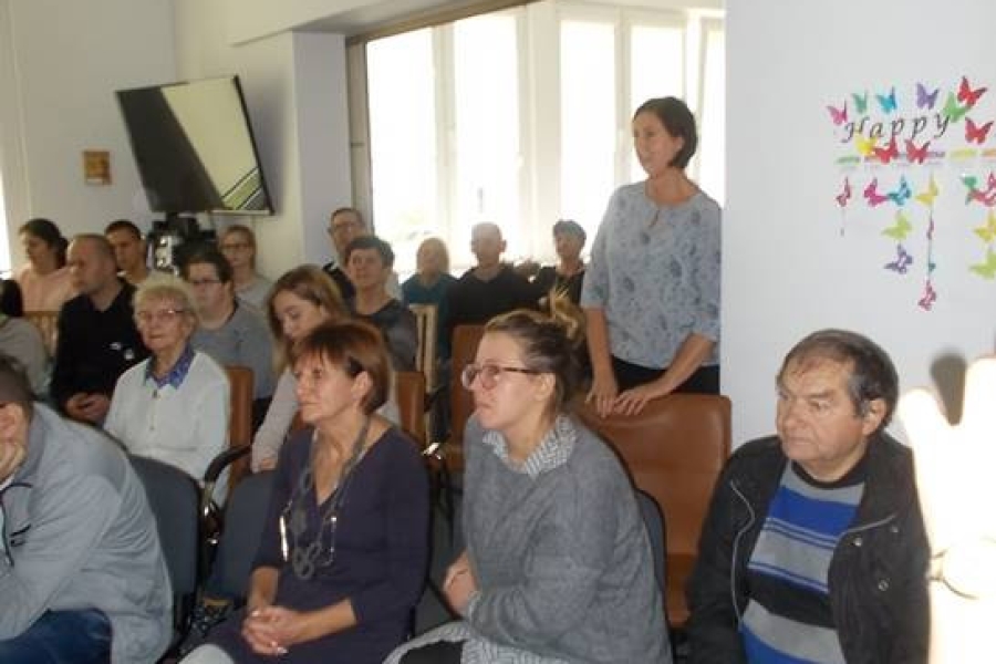 Kadra ŚDS oraz goście siedzący na krześle