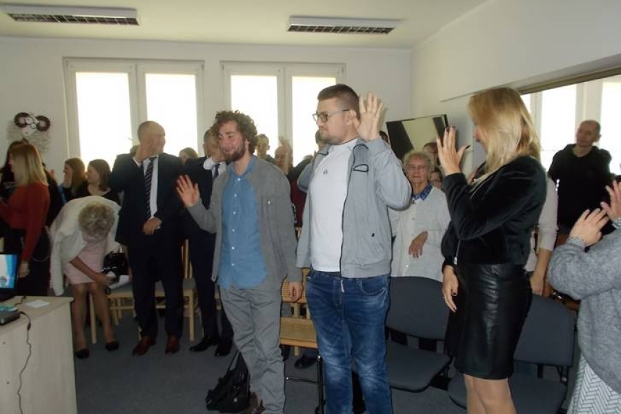 Stojący uczestnicy oraz kadra ŚDS machający dłońmi