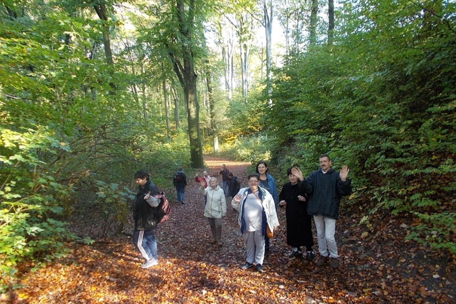 Machający uczestnicy na tle drzew
