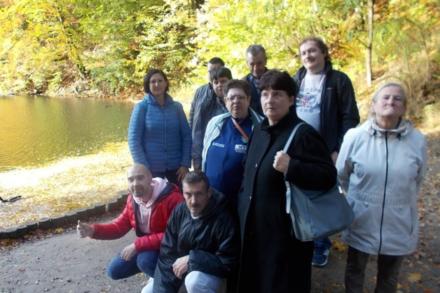 Grupa uczestników oraz terapeutka na tle jeziora