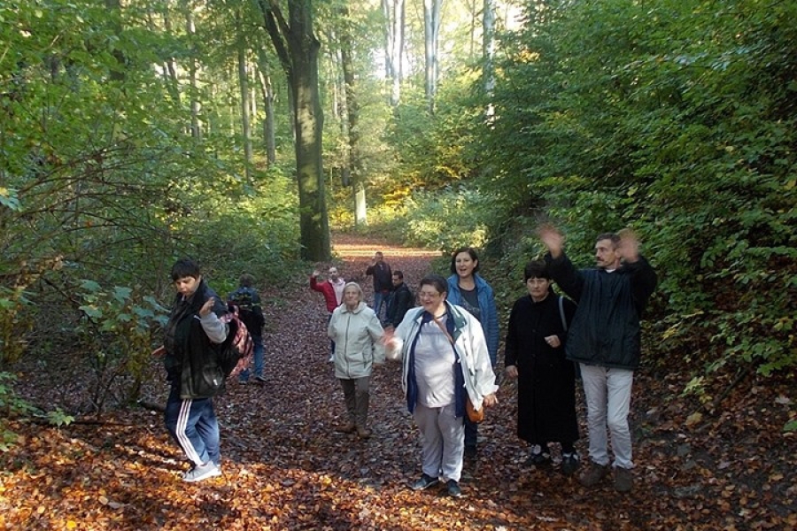 Machający uczestnicy na tle drzew