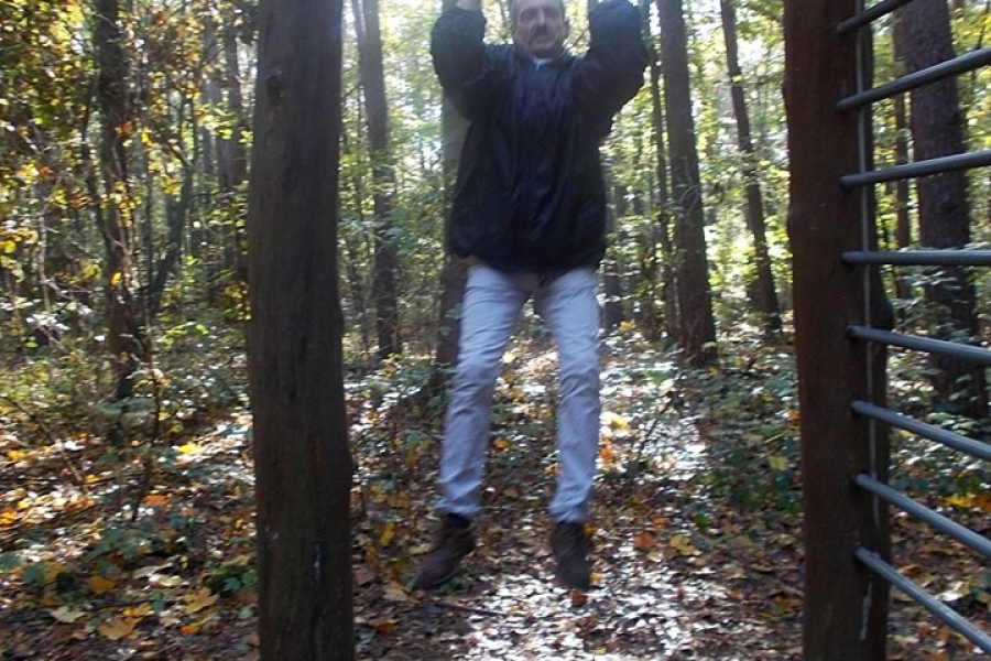 Uczestnik podciągający się na drążku w lesie