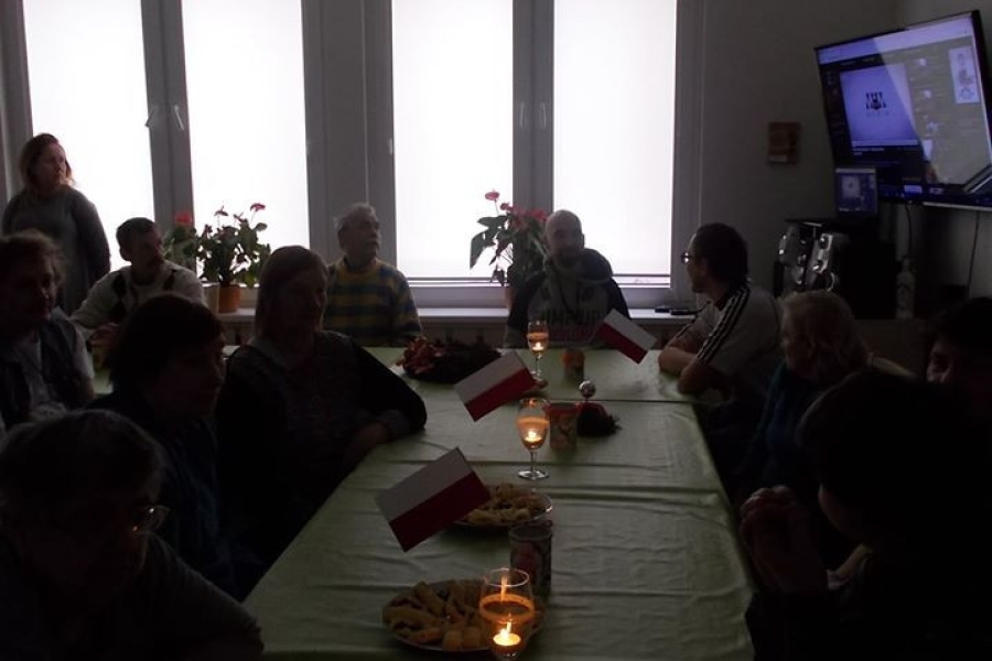 Grupa uczestników przy stole podczas projekcji filmu