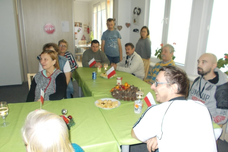 Uczestnicy przy stole przyozdobionym flagami Polski