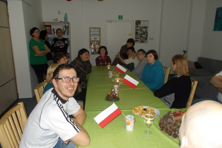 Uczestnicy przy stole przyozdobionym flagami Polski