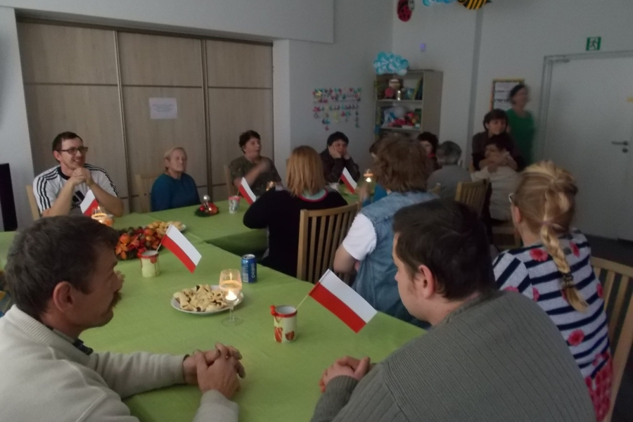 Zdjęcie grupowe uczestników przy stole z zapalonymi świecami