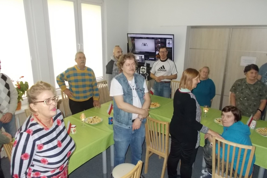 Uczestnicy stojący na baczność przy stole 
