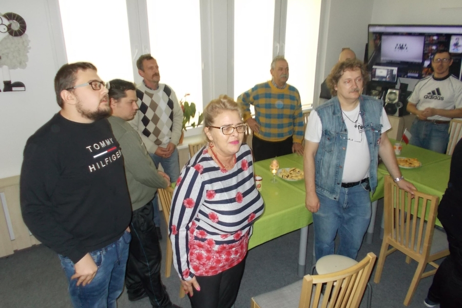 Uczestnicy stojący na baczność przy stole 