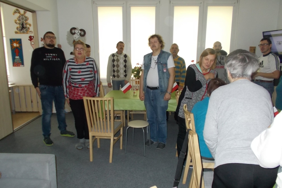 Uczestnicy stojący na baczność przy stole 