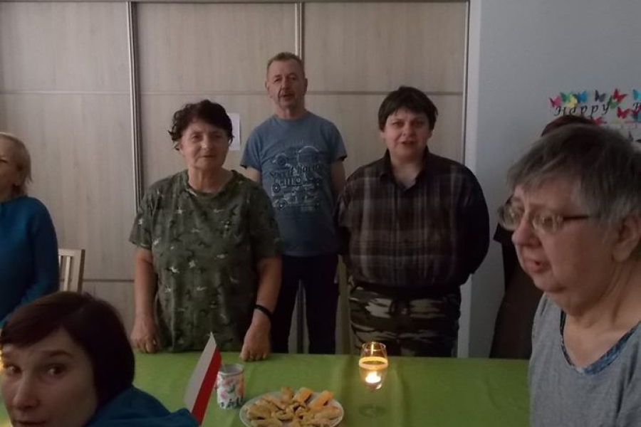 Grupa uczestników stojących przy stole