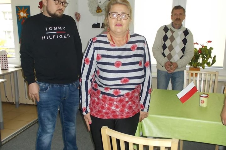 Troje uczestników stojących przy stole